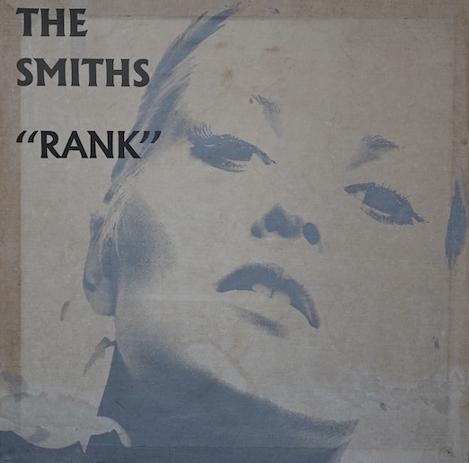 The Smiths interest; a 1980s printed cloth advertising banner mounted on wood stretchers, promoting the live album ‘Rank’, and featuring a close up portrait of Alexandra Bastedo. Condition fair, some staining.